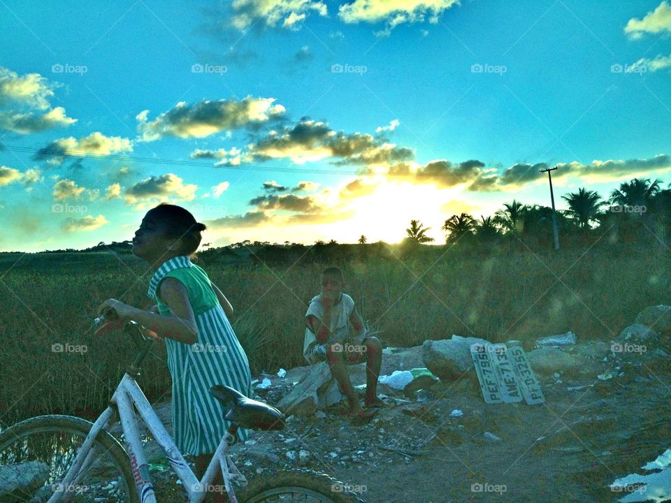 Kids playing . In the middle of nowhere two kids desperately tries to raise some money from the tourists. 