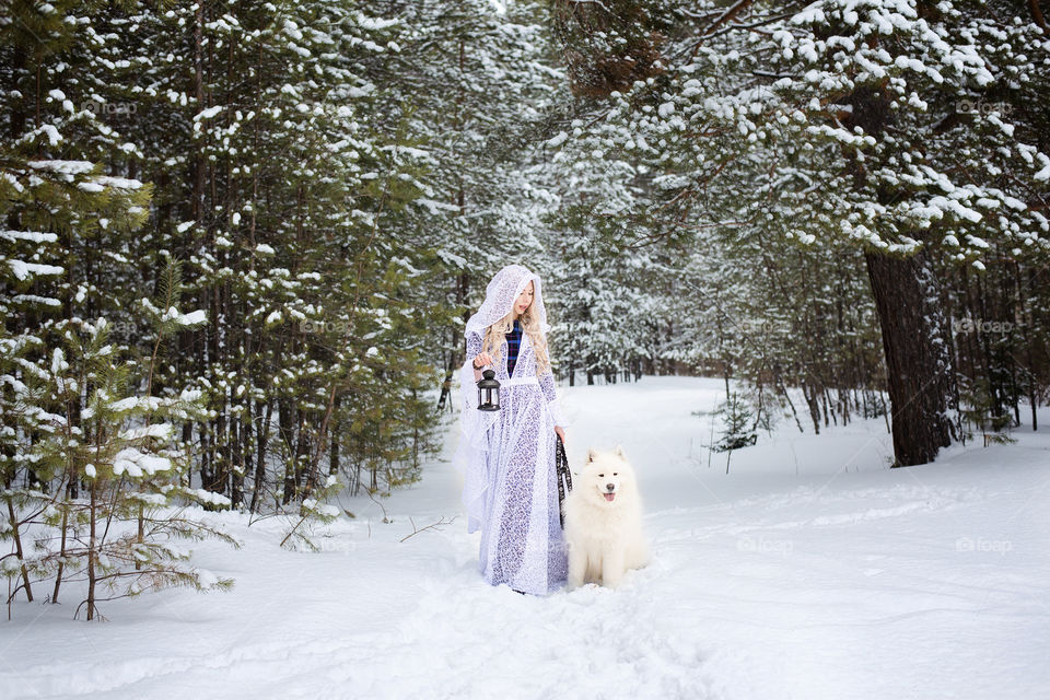 Woman walking with dog in snowy landscape