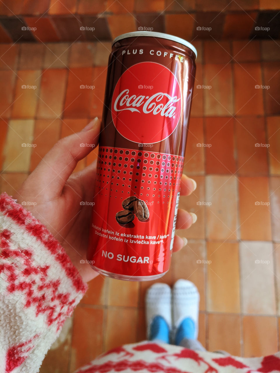 Red can of Coca- Cola without sugar in my hand close up. Top view.