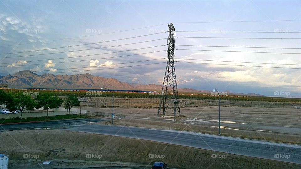 Desert landscape after the storm with railroad train in the  background.