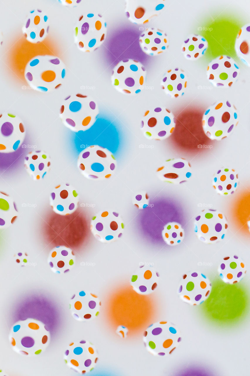 Shapes circles and ellipses using bright colorful circle background and many water drops reflecting the shape. Flat lay macro with white background