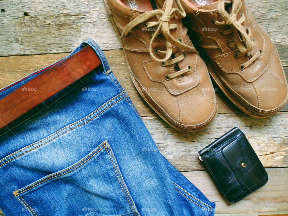 jeans, men's leather shoes and wallet lay on the boards