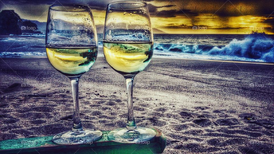 wine at the beach. enjoying a glass of wine while enjoying the sunset on the beach