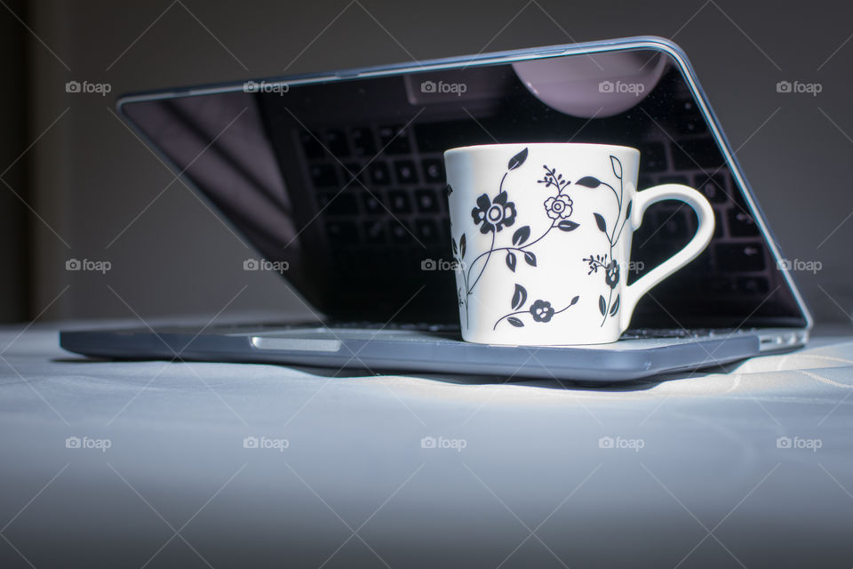 cup of coffee on notebook macbook pro