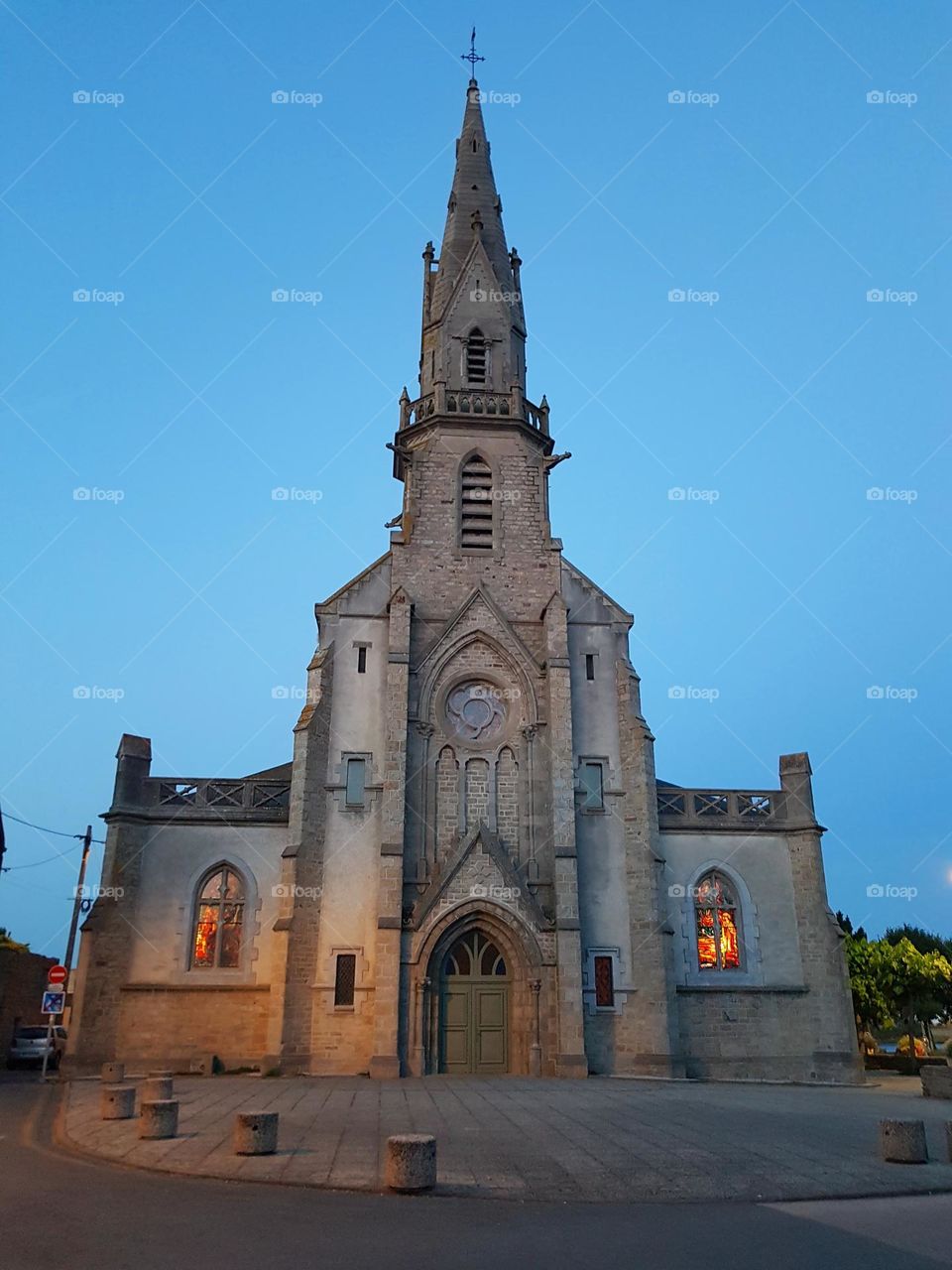 Illuminated stained glass windows of Sainte-Radegonde church in Riantec at nightfall