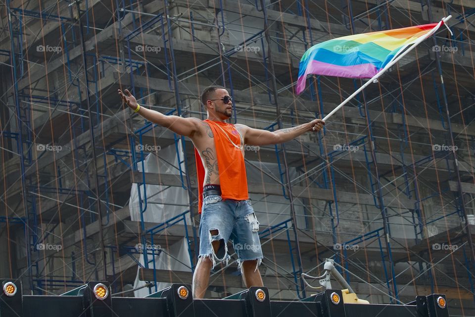 A man on top of a garbage truck waving a Gay Pride Flag at the Annual New York City, Manhattan, USA