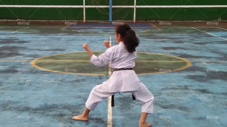 a young girl training karate alone