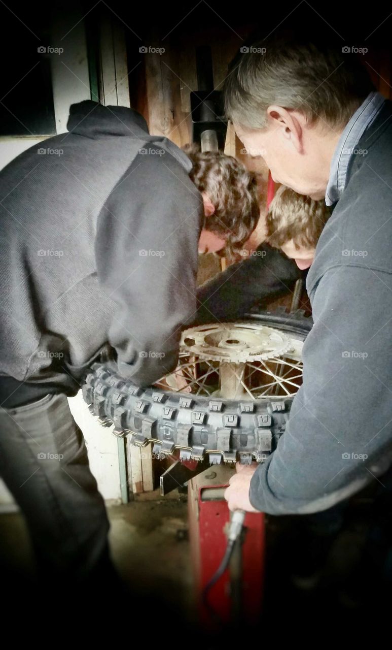 Dad Teaching Teenage Sons  Change a Motorcycle Tire