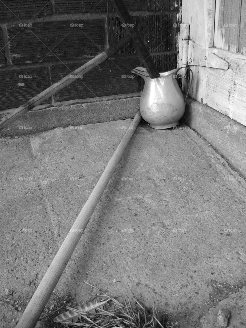 Pitcher. aluminum pitcher, take and feather by brick wall and barn door