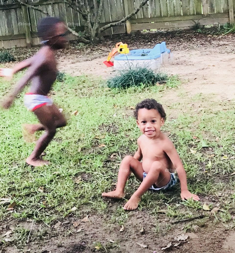 These two backyard lovers enjoy  running and playing in their underwear on a cloudy day after a rain. 