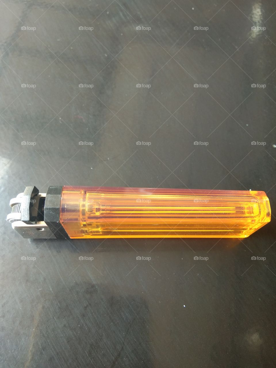 yellow gas lighter with a black background