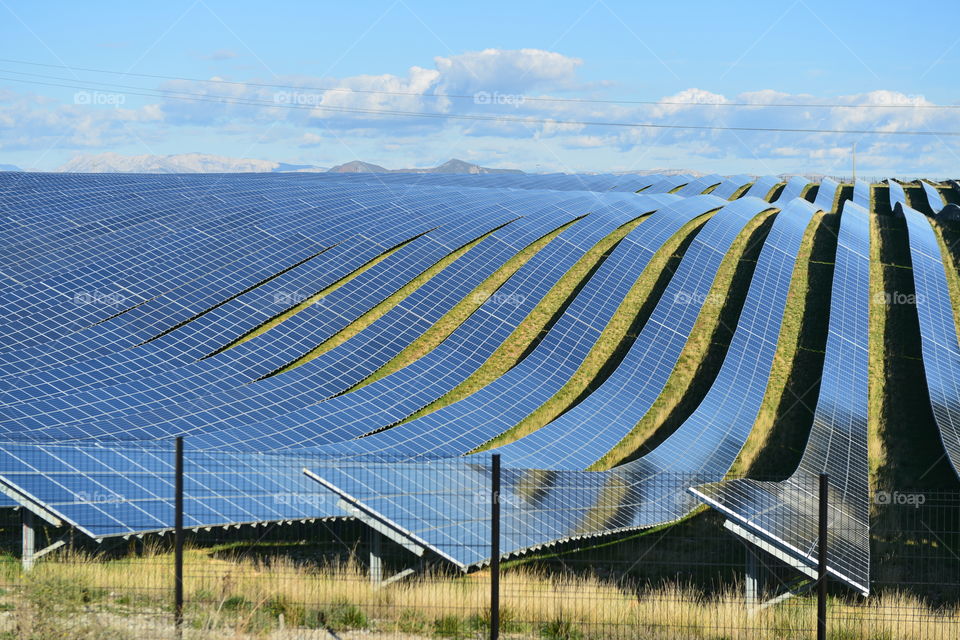 Green Energy Solar Farm with many Photovoltaic Panels across Acres of land