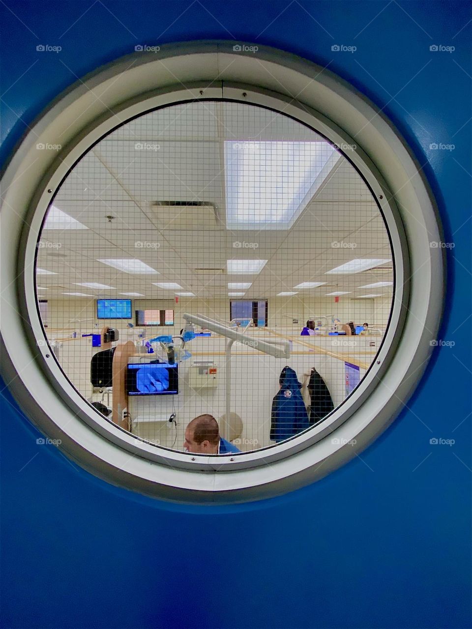 This naval style circular porthole window reveals the „NYU Kriser Dental Center“ at „East 24th St“ in „Manhattan“, NY. For a relatively modest fee people without dental insurance receive emergency services here and more. 2023. Hypnotic Productions
