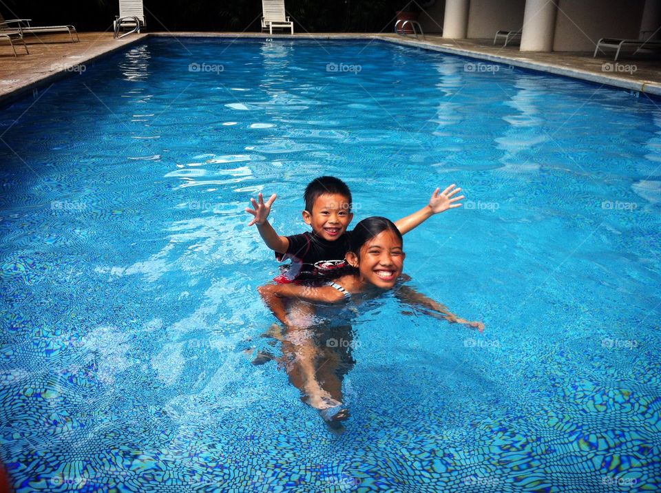 Brother and sister enjoying in swimming pool