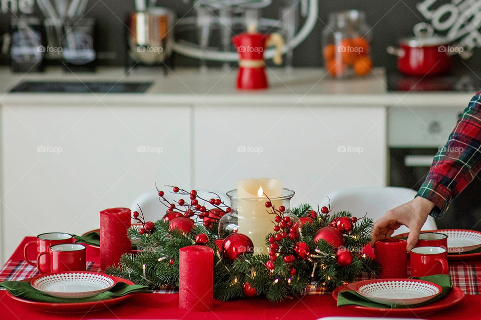 man sets a beautiful decorated winter table for a festive dinner.  Merry Christmas and Happy New Year.