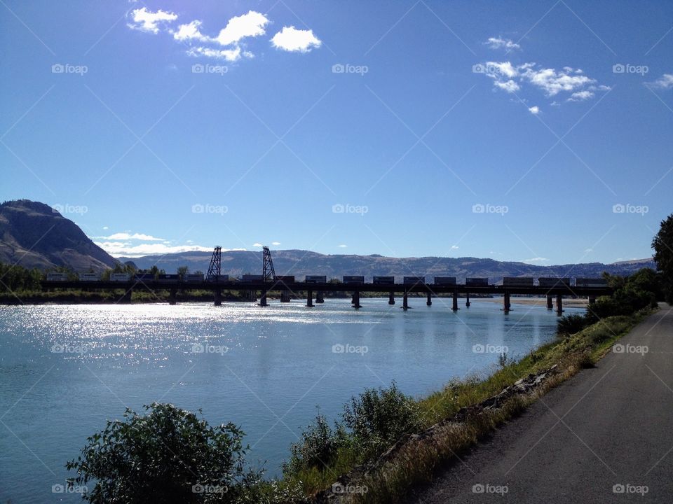 Train passing over a river on a beautiful sunny day in Kamloops British Colombia, Canada 