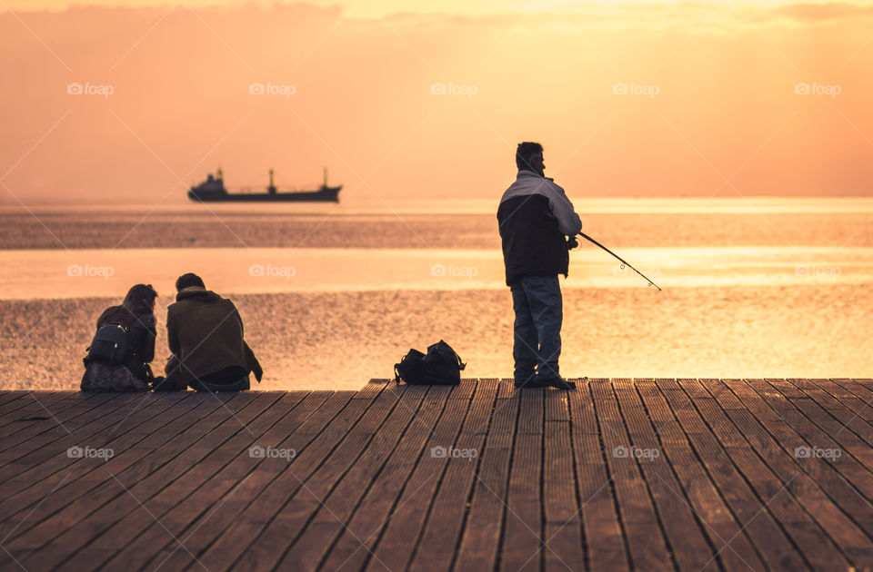 People Enjoying And Fishing On Sunset
