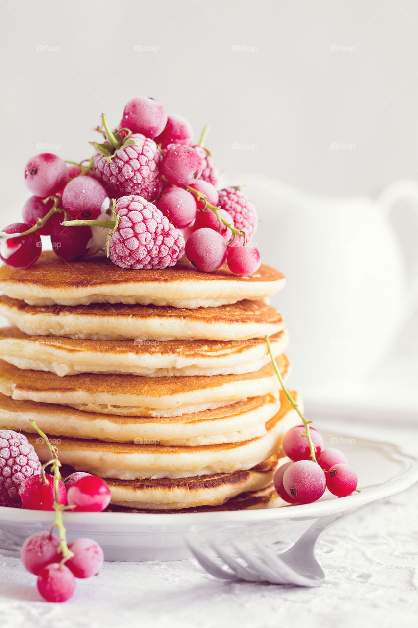 Stack of pancakes with frozen berries