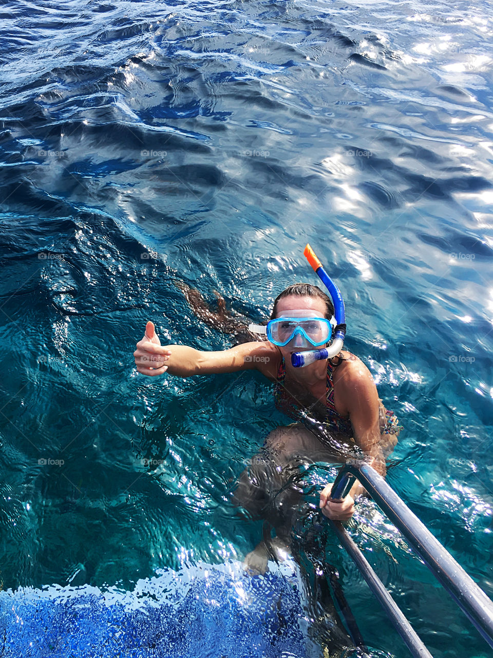 Young woman diving with a mask into the ocean 
