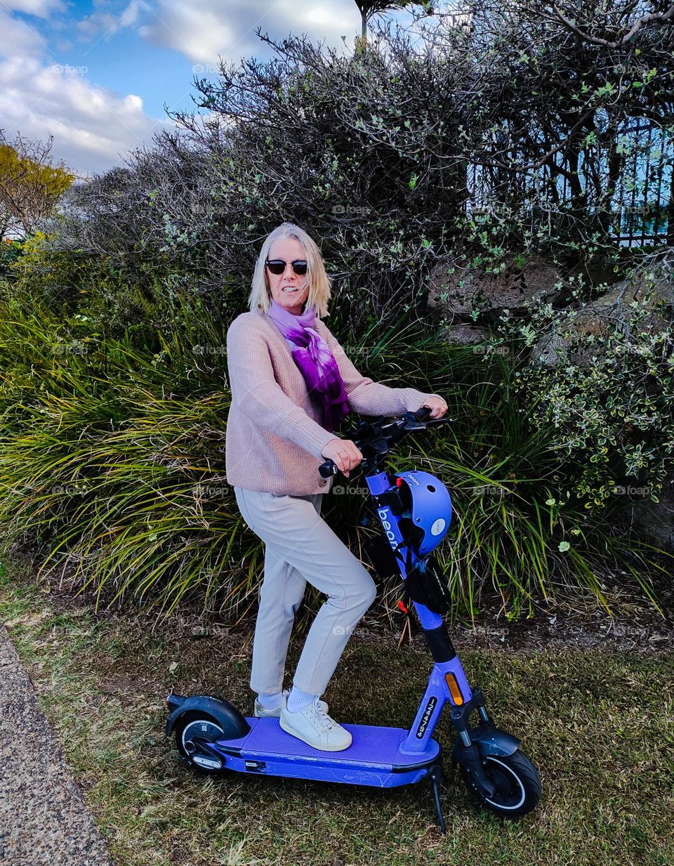 Blonde scandinavian woman riding her e-scooter