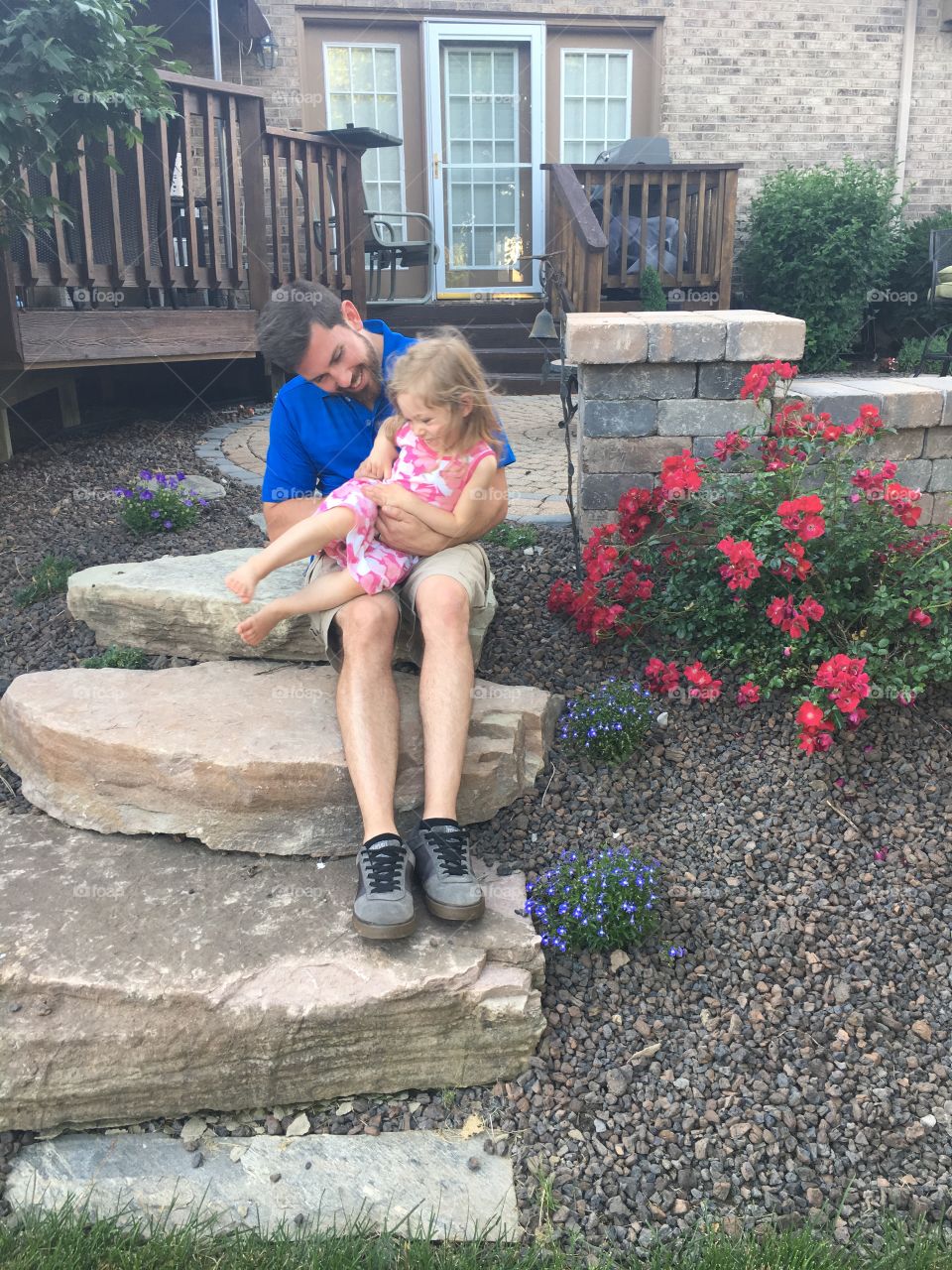 Daughter and girl sitting on rock