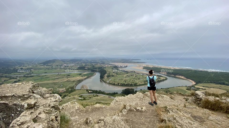 Girl taking a photo of the landscape while on a hike 