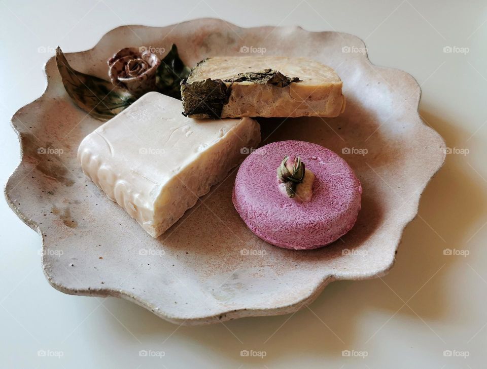 Soap and shampoo bars on a ceramic plate