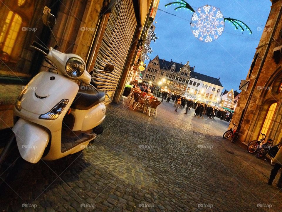 Moped during Brugge Holidays. A moped is stowed away from the hustle and bustle of holiday festivities in Brugge, Belgium. 