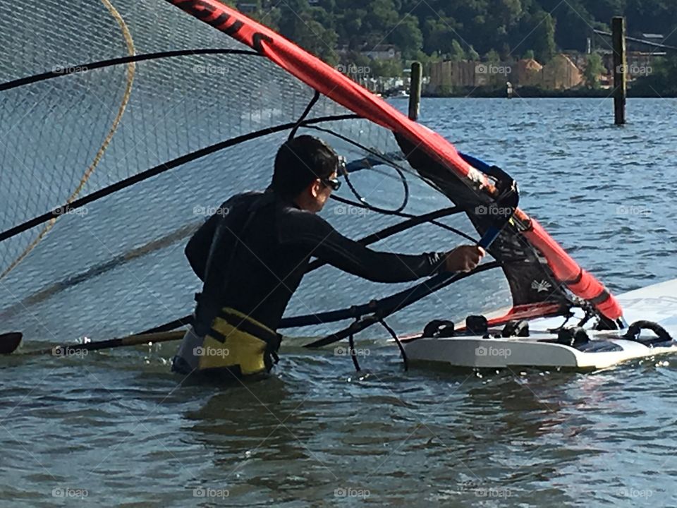 Man in water about to go windsurfing