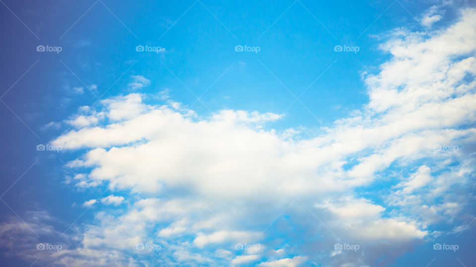 Large clouds float across the sunset sky like sails.