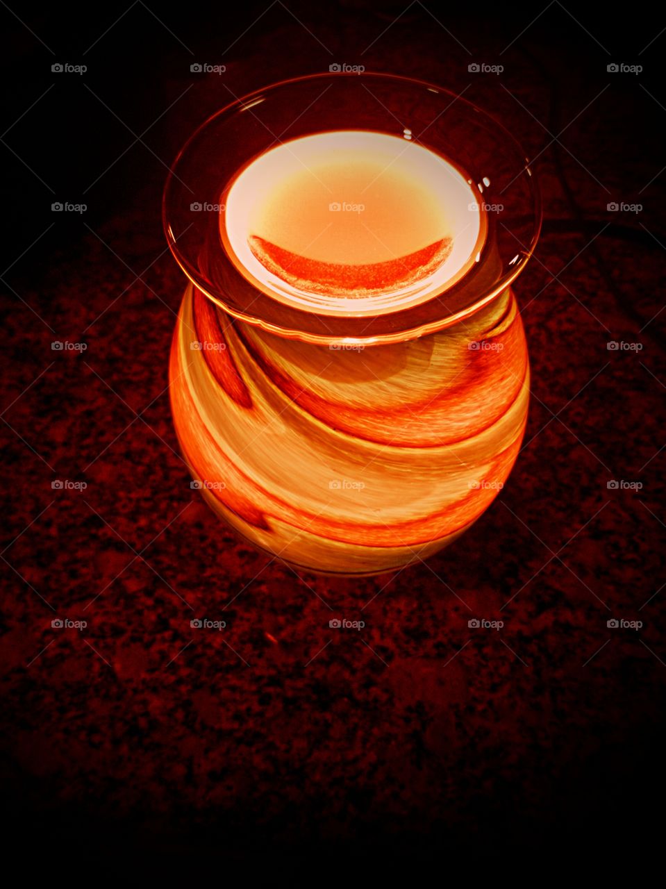 An Orange Glow Radiates From A Wax Warmer On Granite And A Vigenette Edit To Assist With The Already Dark Background.