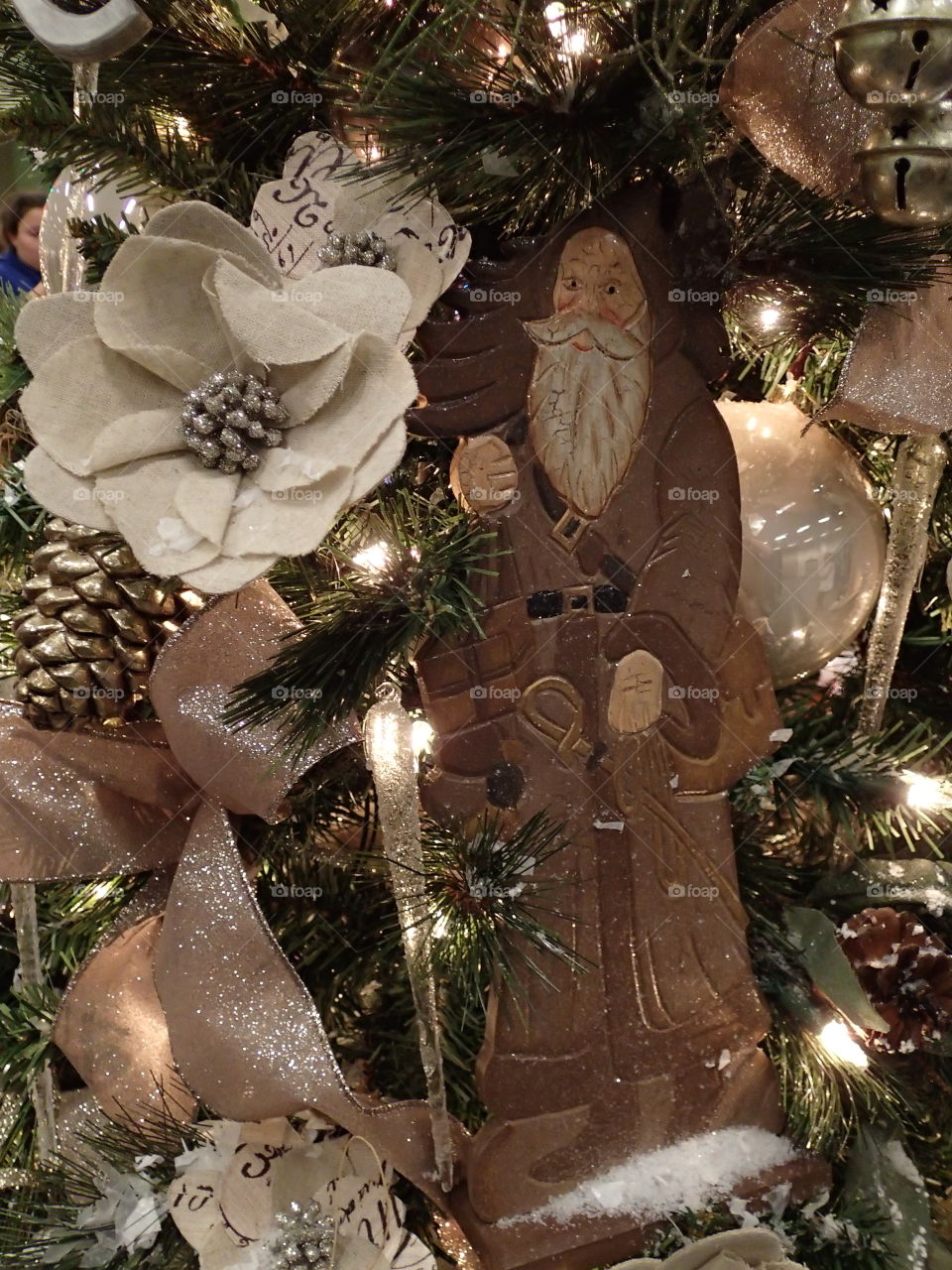 An old fashioned Santa Claus Christmas ornament on a very beautiful Christmas tree during the holiday season. 