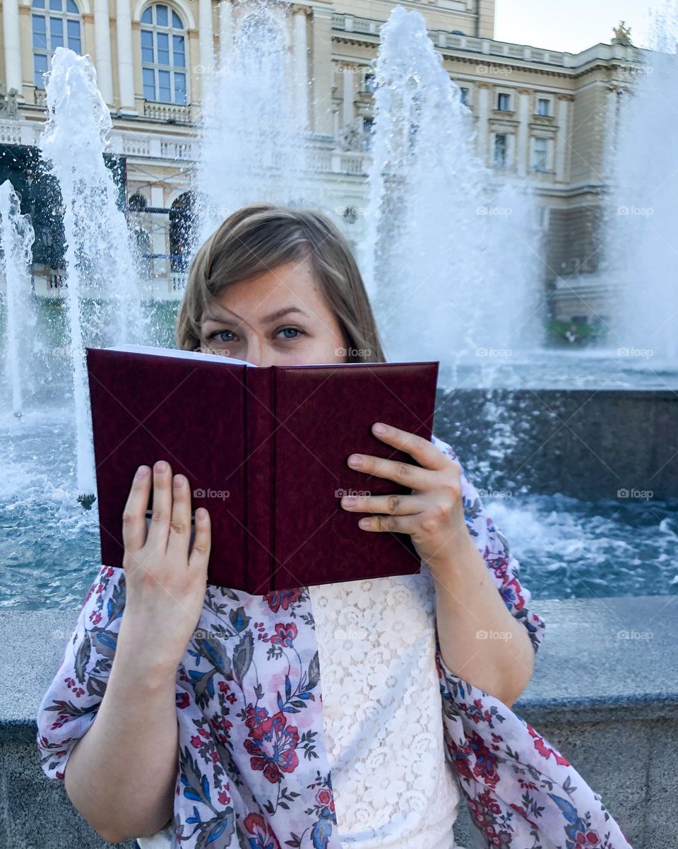 Portrait woman with note near fountain 