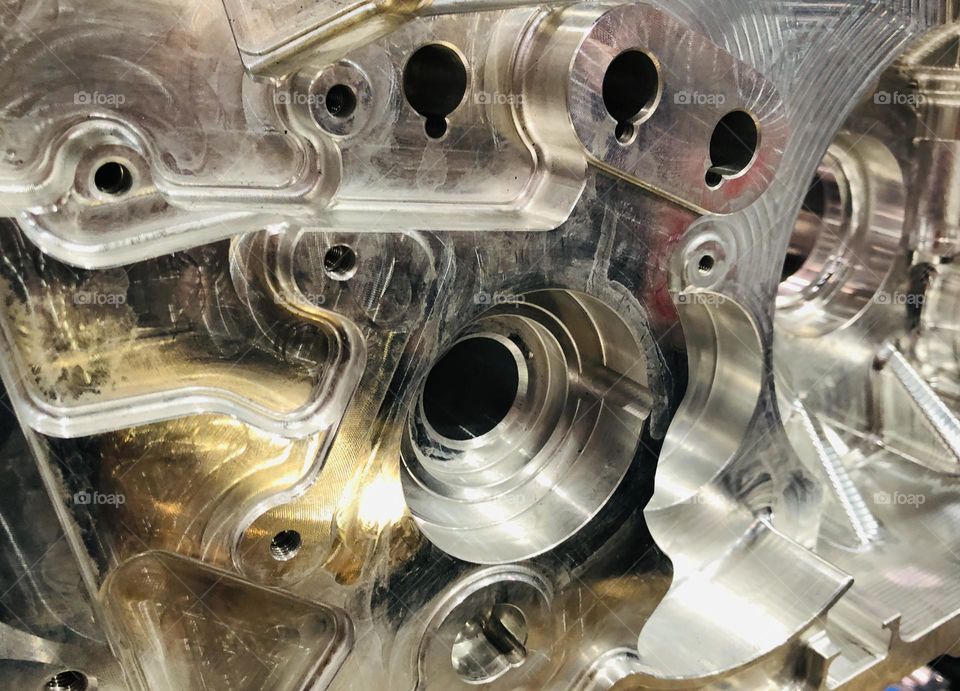 Closeup view inside an aluminum engine shiny metal contrasts with dark open spaces 