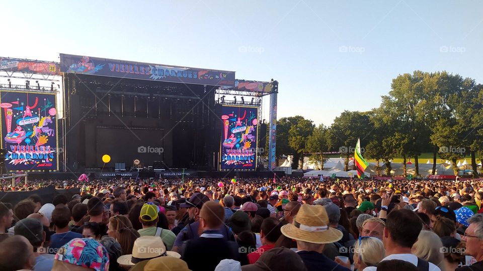 At sunset, the crowd waits for the start of a concert during the festival "Les Vieilles Charrues" in Brittany.