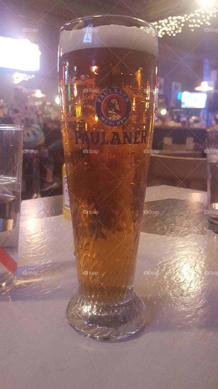 Tall pint of beer in a bar