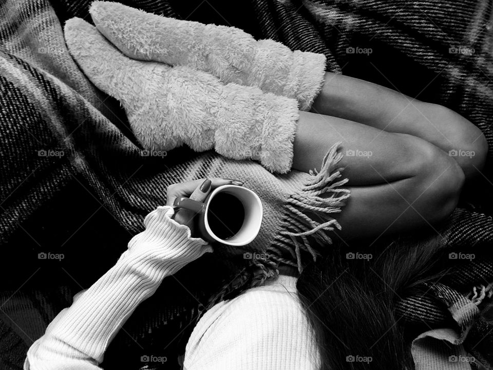 Overheard view of drinking coffee in cozy bed in cozy home boots