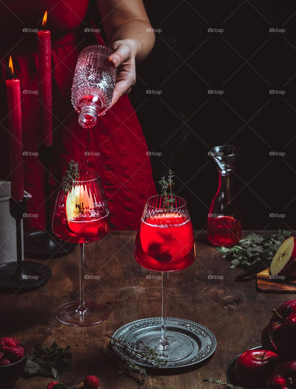 Woman prepares cozy red berries cocktail with red apple