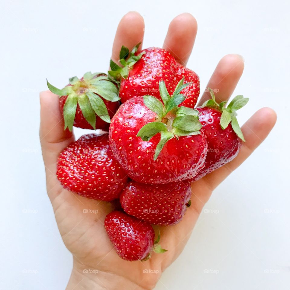 Sweet strawberry season. A hand full of strawberries 