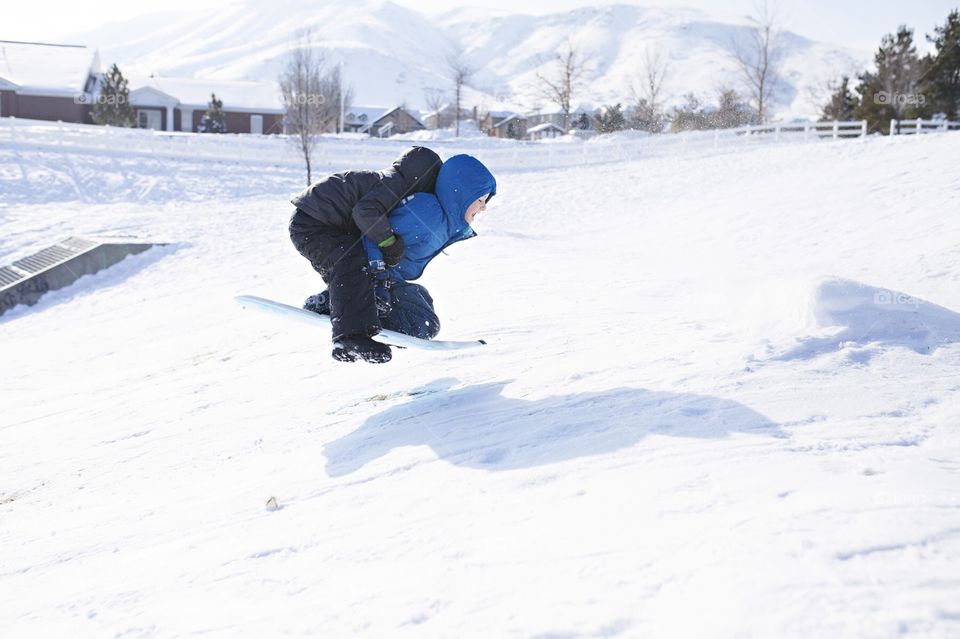 Kids sledding down a hill in winter 