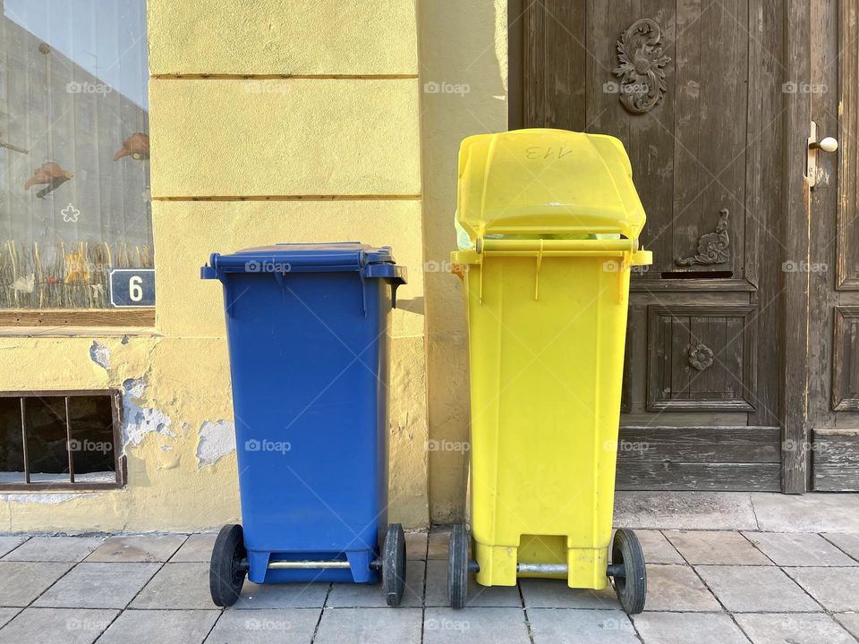 Yellow and blue trash bins outdoor 