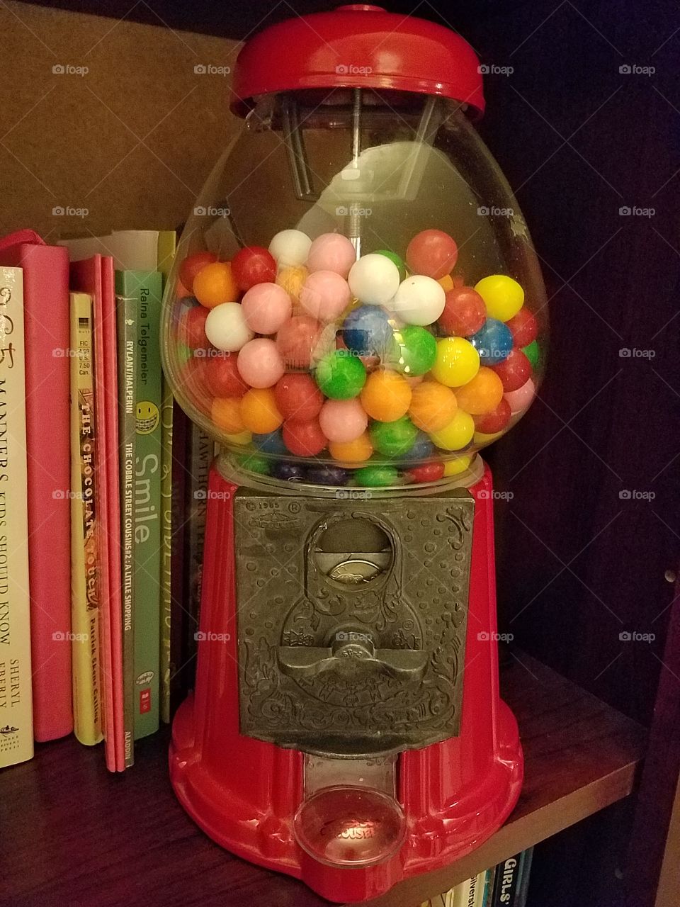 Red bubble gum machine full of colored gumballs