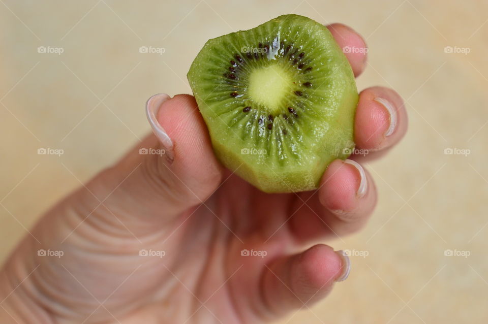 Peeled kiwi fruit in human hand