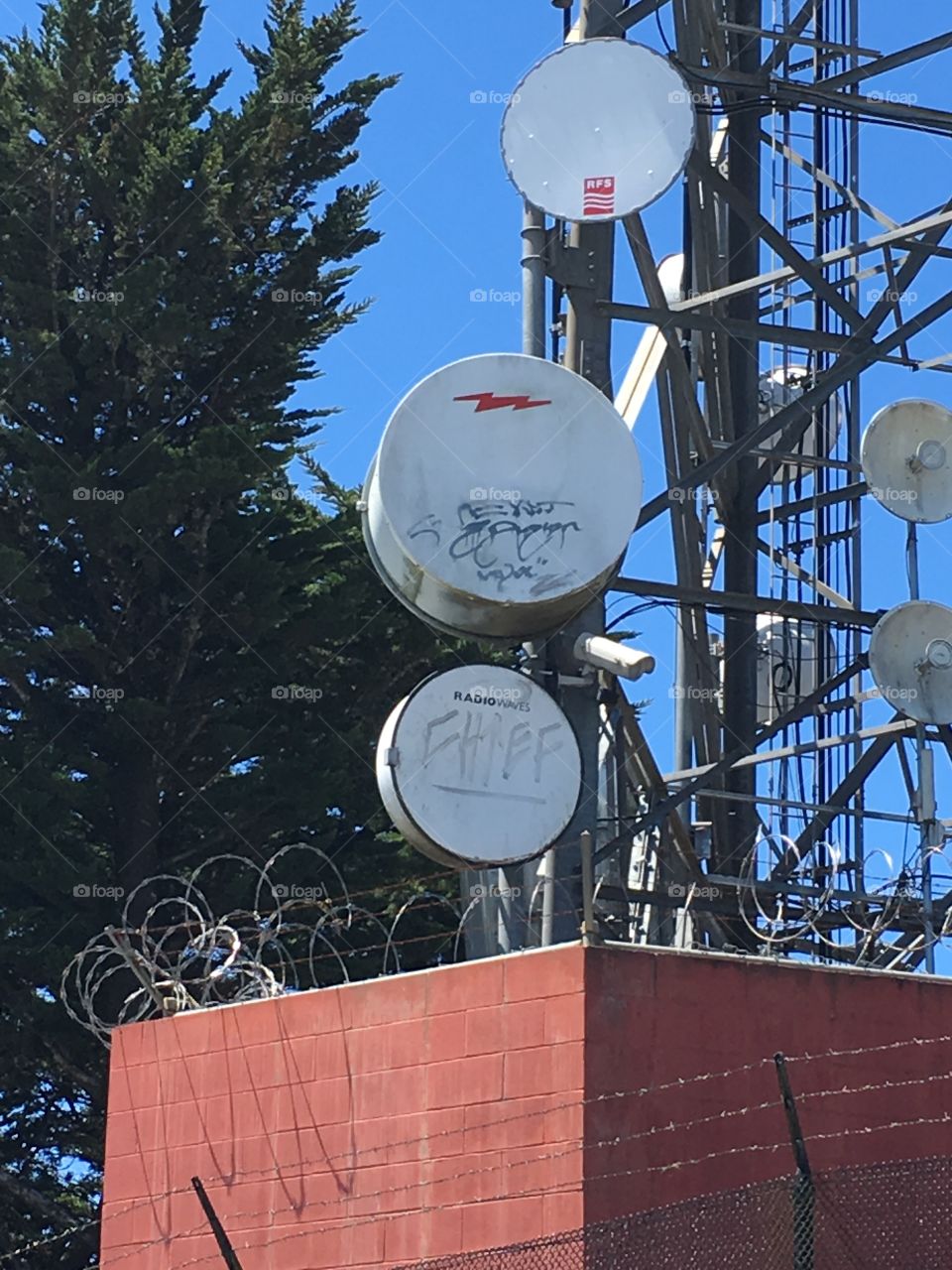 A graffitied telecommunications tower. 