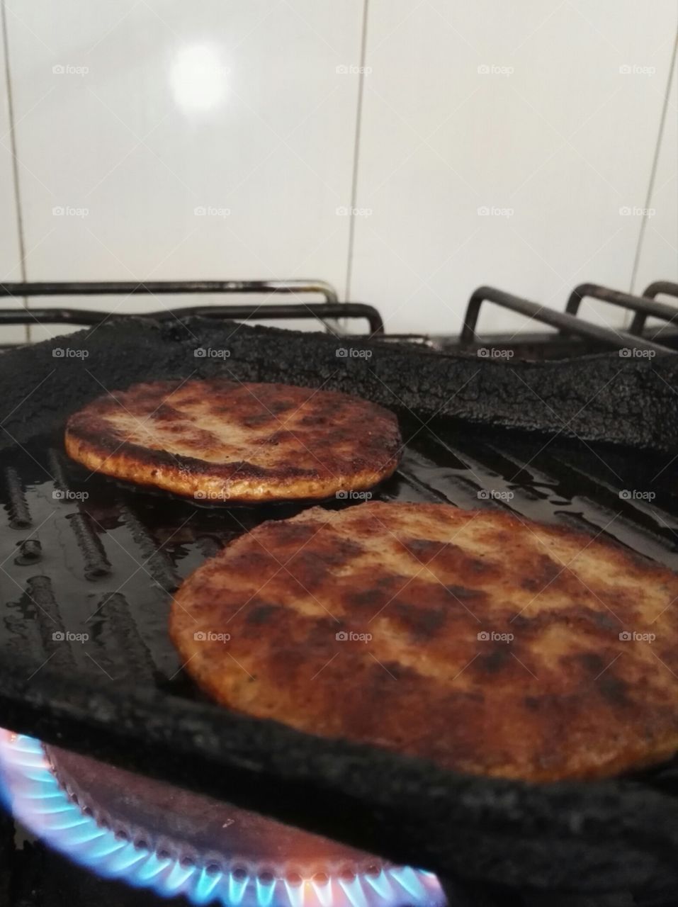 two burgers on grill