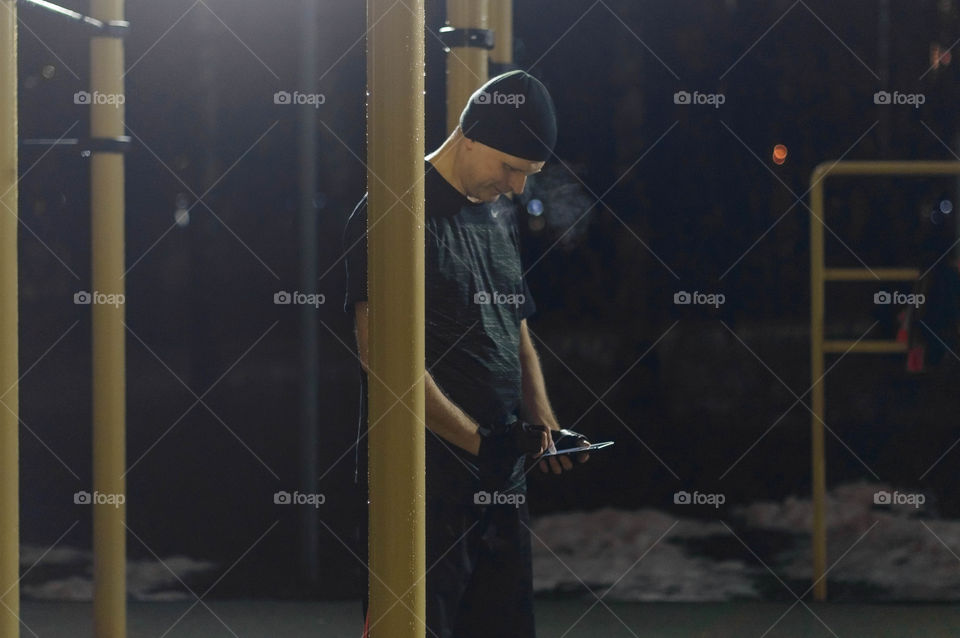 A man using a smartphone on a sports ground