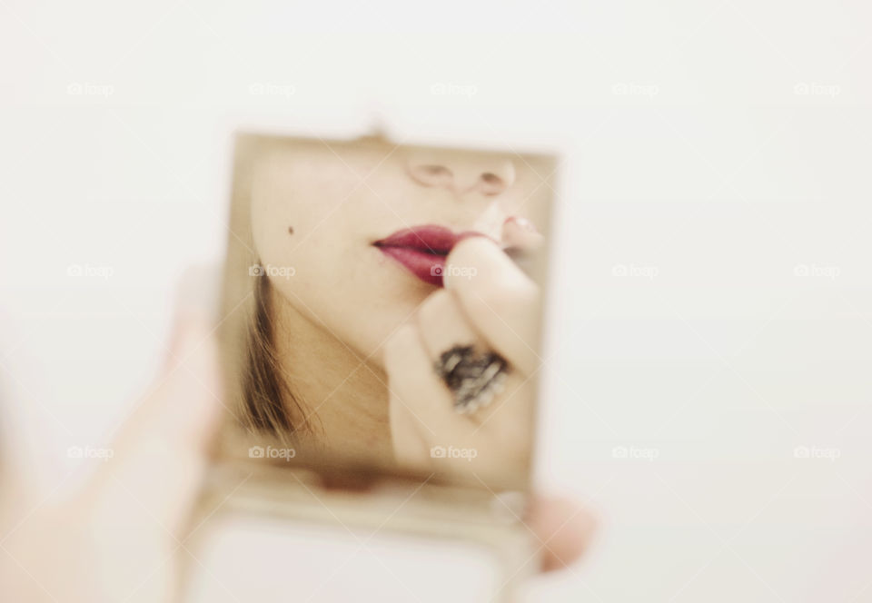 Woman putting lipstick on 