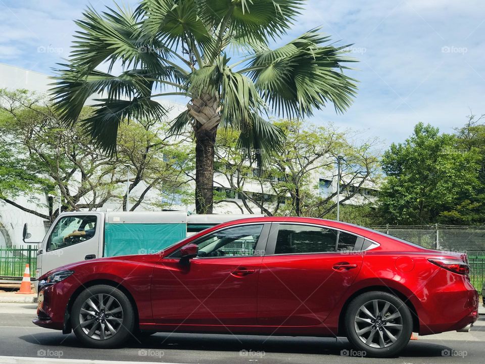 A red car on her way on road 