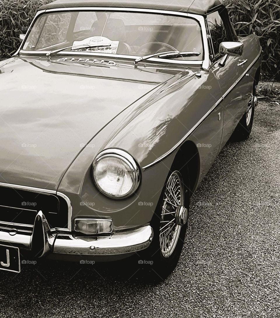 Sideway sepia shot of an MG Cabriolet showing part of the front grill and one front light at Cherbourg car show