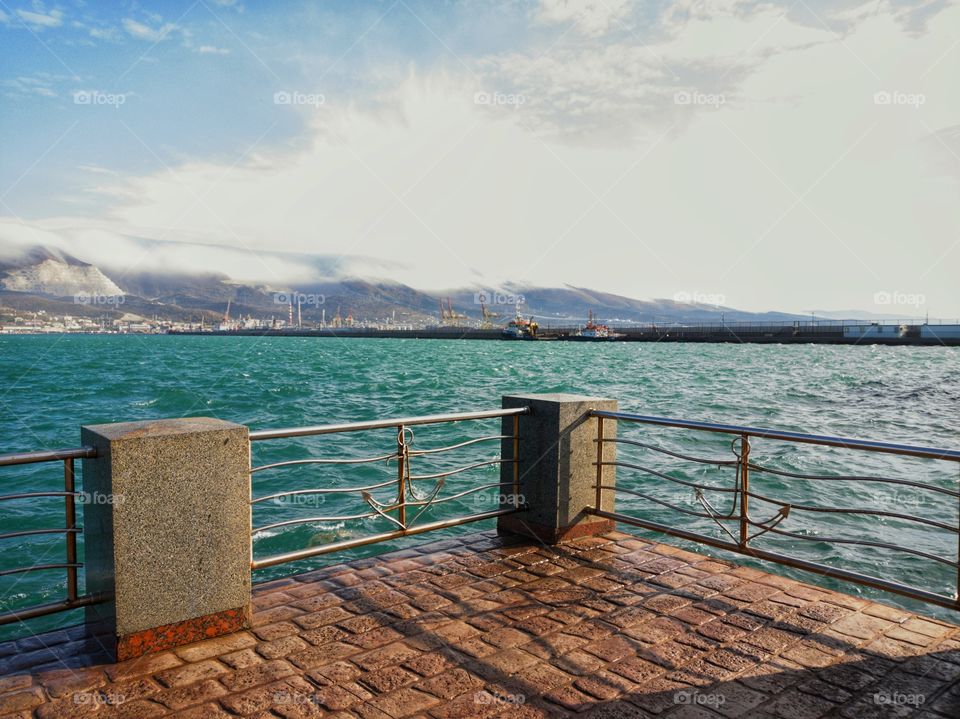 Waves on the sea. A mountain range in the clouds. Clouds are floating because of the strong wind.